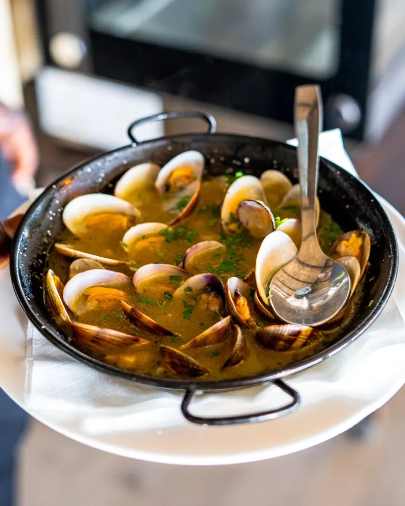 Clams in white wine with garlic and parsley in a small pan