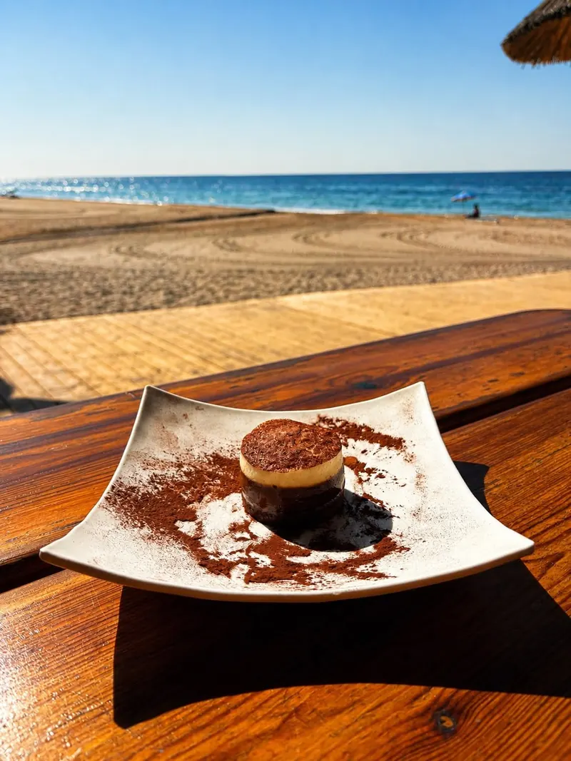 A dessert on a wooden table with the sea in the background