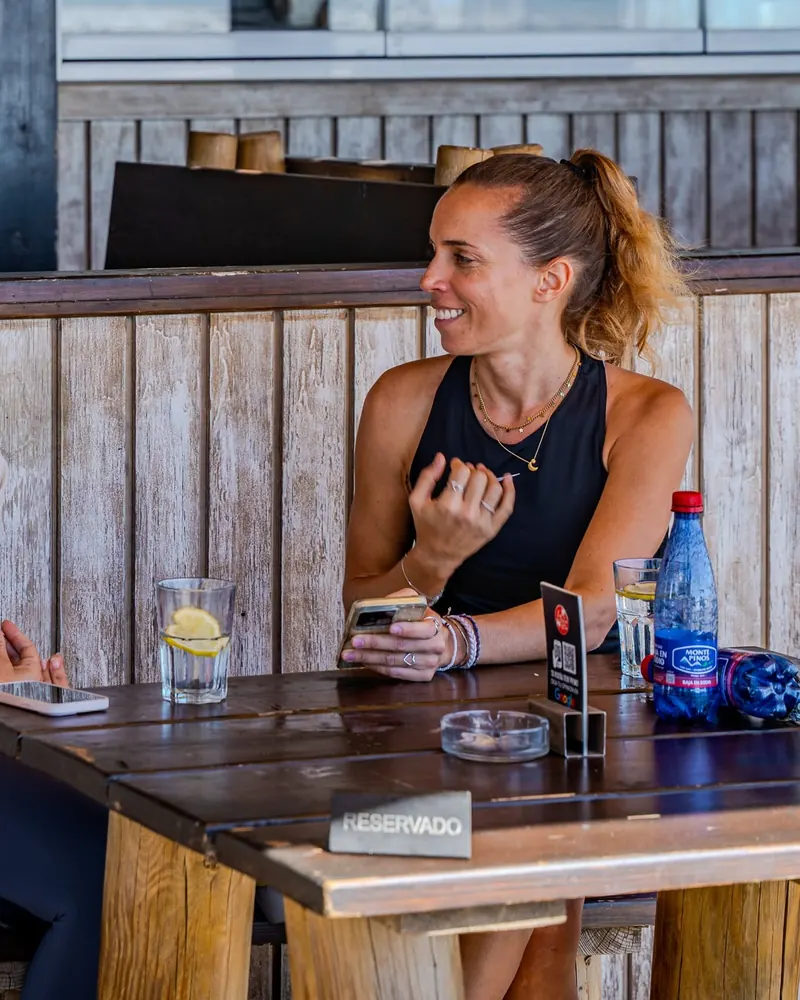A guest smiling at a wooden table