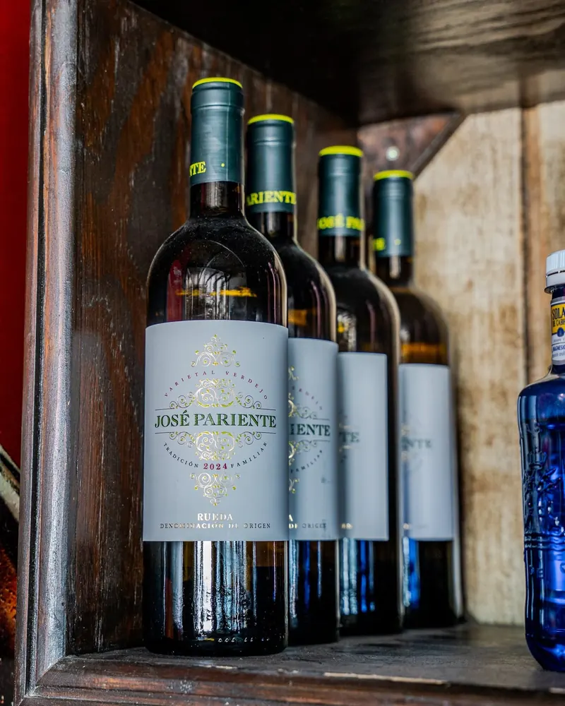 Bottles of José Pariente white wine on a wooden shelf